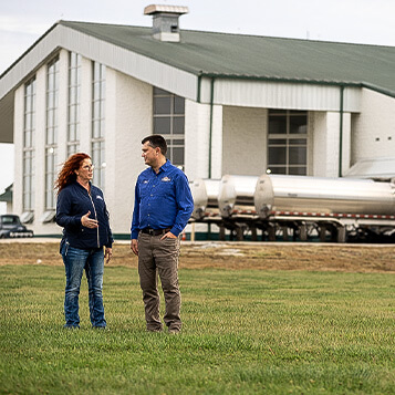 Natural-Choice-Dairy-0064.jpg A farmer and operator have a discussion while standing in a field of grass.