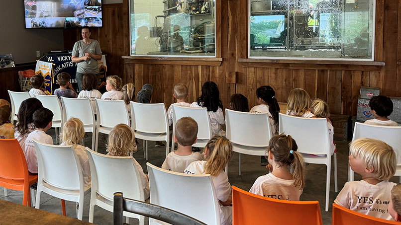 LenkTour3_806x453px.jpg Children learning about dairy farming during an educational farm visit inside a dairy facility.